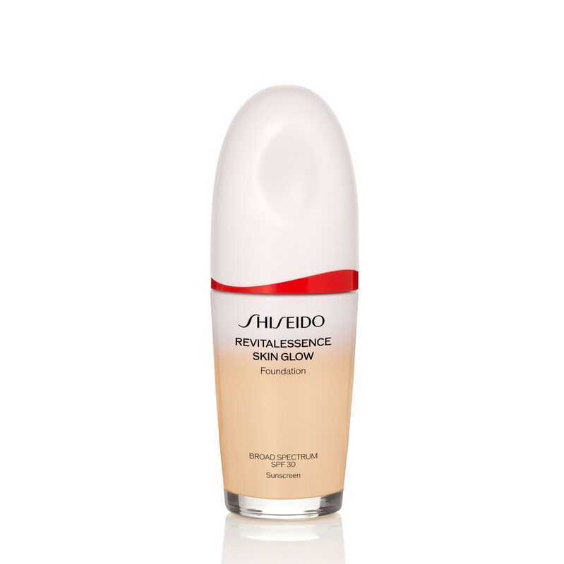 An oval-shaped bottle of Shiseido Revitalessence Skin Glow Foundation SPF 30 in shade 140 Porcelain. The label on the bottle is white with a red accent. The text on the label reads the product&rsquo;s title, and its sunscreen protection.