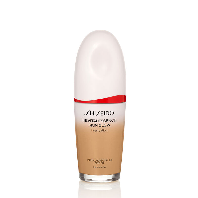 "An oval-shaped bottle of Shiseido Revitalessence Skin Glow Foundation SPF 30 in shade 350 Maple. The label on the bottle is white with a red accent. The text on the label reads the product&rsquo;s title, and its sunscreen protection. "