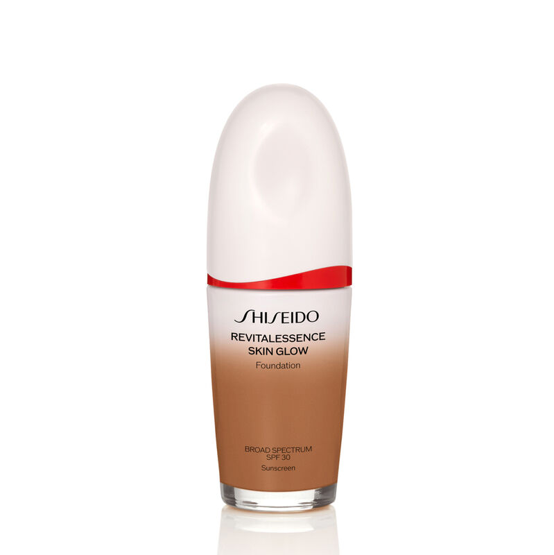 "An oval-shaped bottle of Shiseido Revitalessence Skin Glow Foundation SPF 30 in shade 430 Cedar. The label on the bottle is white with a red accent. The text on the label reads the product&rsquo;s title, and its sunscreen protection. "