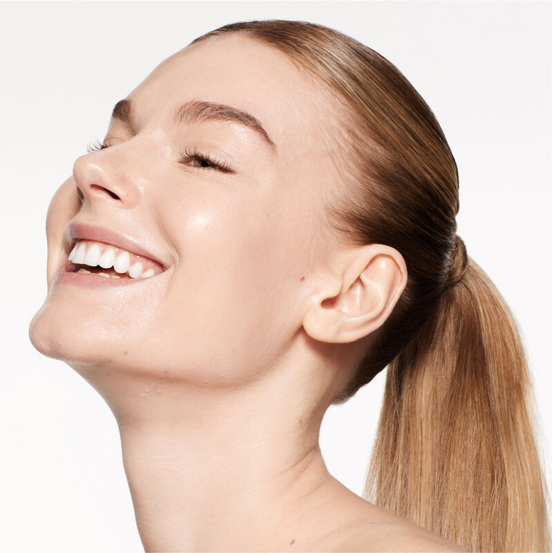 A headshot of a model wearing the Shiseido Revitalessence Skin Glow Foundation SPF 30 in shade 160 Shell. The models&rsquo; skin appears more smooth and glowy with the foundation's medium-coverage finish. 