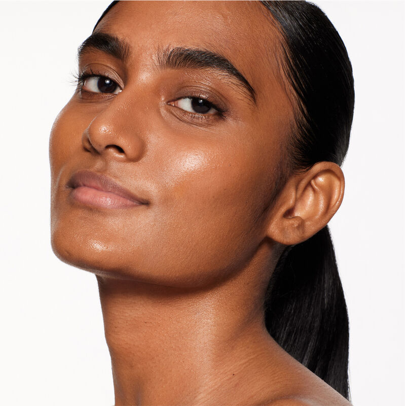 "A headshot of a model wearing the Shiseido Revitalessence Skin Glow Foundation SPF 30 in shade 430 Cedar. The models&rsquo; skin appears more smooth and glowy with the foundation's medium-coverage finish.  "