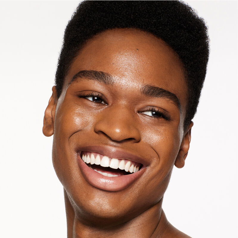 "A headshot of a model wearing the Shiseido Revitalessence Skin Glow Foundation SPF 30 in shade 510 Suede. The models&rsquo; skin appears more smooth and glowy with the foundation's medium-coverage finish.  "