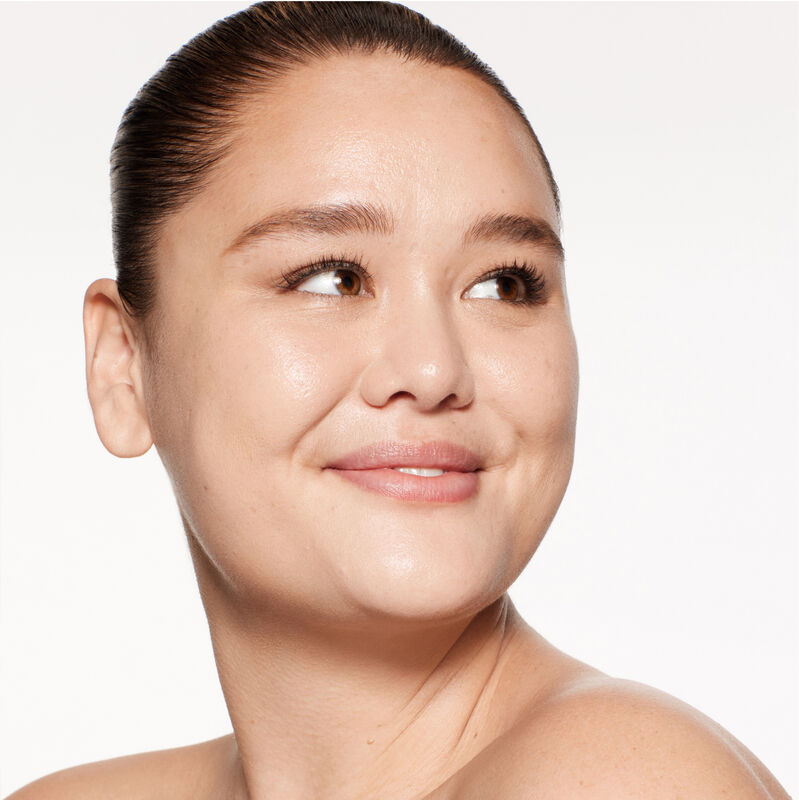 "A headshot of a model wearing the Shiseido Revitalessence Skin Glow Foundation SPF 30 in shade 250 Sand. The models&rsquo; skin appears more smooth and glowy with the foundation's medium-coverage finish.  "