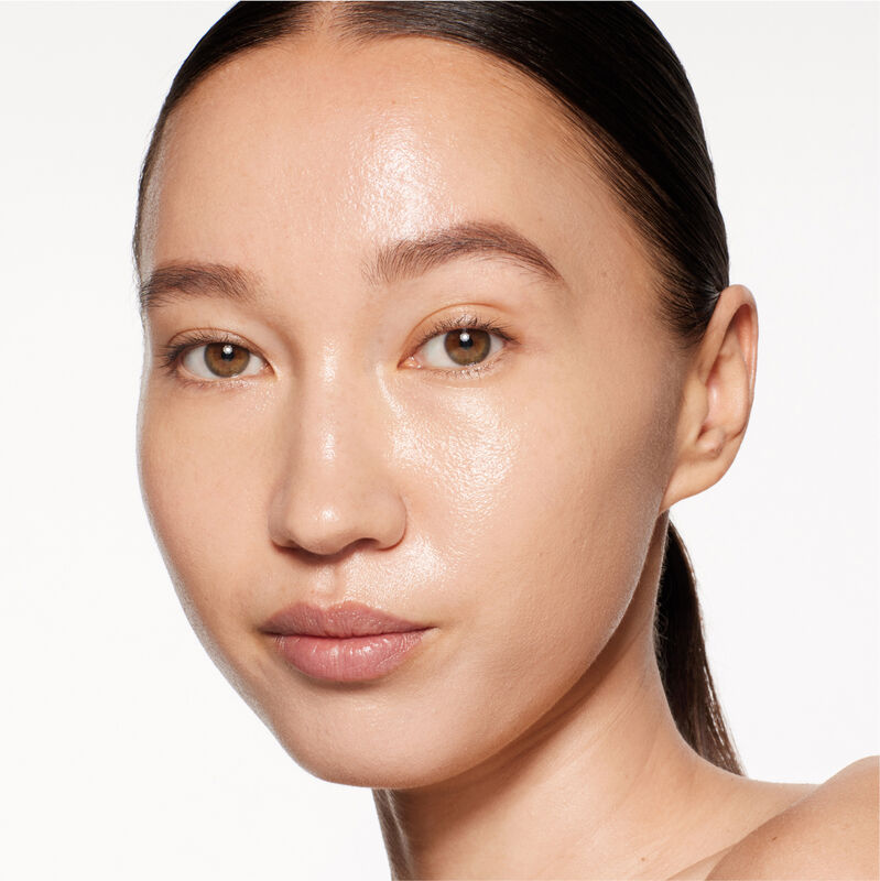 A headshot of a model wearing the Shiseido Revitalessence Skin Glow Foundation SPF 30 in shade 310 Silk. The models&rsquo; skin appears more smooth and glowy with the foundation's medium-coverage finish. 