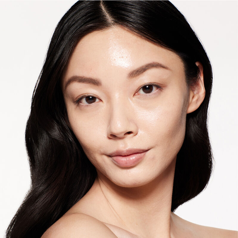A headshot of a model wearing the Shiseido Revitalessence Skin Glow Foundation SPF 30 in shade 210 Birch. The models&rsquo; skin appears more smooth and glowy with the foundation's medium-coverage finish.