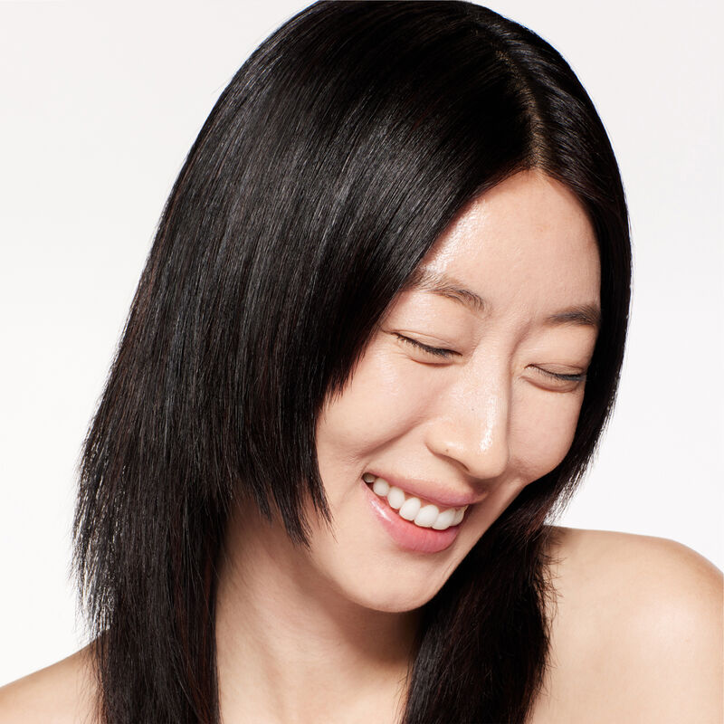  A headshot of a model wearing the Shiseido Revitalessence Skin Glow Foundation SPF 30 in shade 150 Lace. The models&rsquo; skin appears more smooth and glowy with the foundation's medium-coverage finish. 