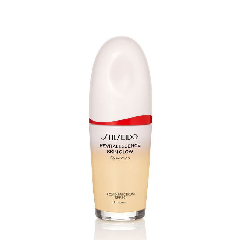 An oval-shaped bottle of the Shiseido Revitalessence Skin Glow Foundation SPF 30 in shade 120 Ivory. The label on the bottle is white with a red accent. The text on the label reads the product&rsquo;s title, and its sunscreen protection.