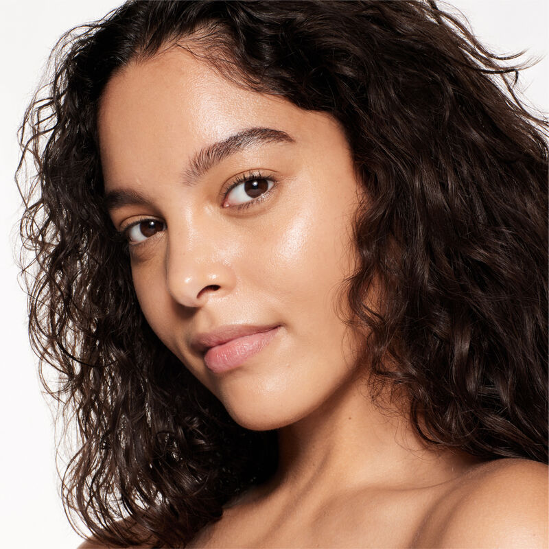 "A headshot of a model wearing the Shiseido Revitalessence Skin Glow Foundation SPF 30 in shade 340 Oak. The models&rsquo; skin appears more smooth and glowy with the foundation's medium-coverage finish.  "