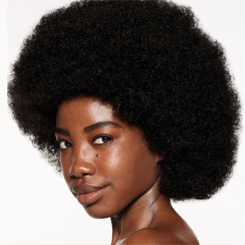 "A headshot of a model wearing the Shiseido Revitalessence Skin Glow Foundation SPF 30 in shade 450 Copper. The models&rsquo; skin appears more smooth and glowy with the foundation's medium-coverage finish.  "