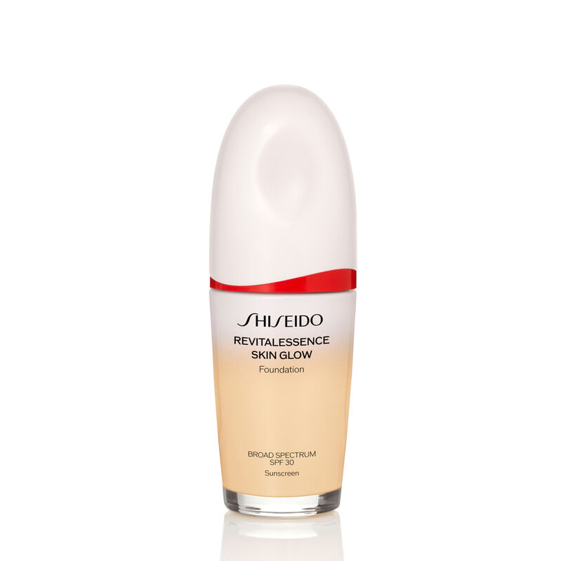An oval-shaped bottle of the Shiseido Revitalessence Skin Glow Foundation SPF 30 in shade 130 Opal. The label on the bottle is white with a red accent. The text on the label reads the product&rsquo;s title, and its sunscreen protection.
